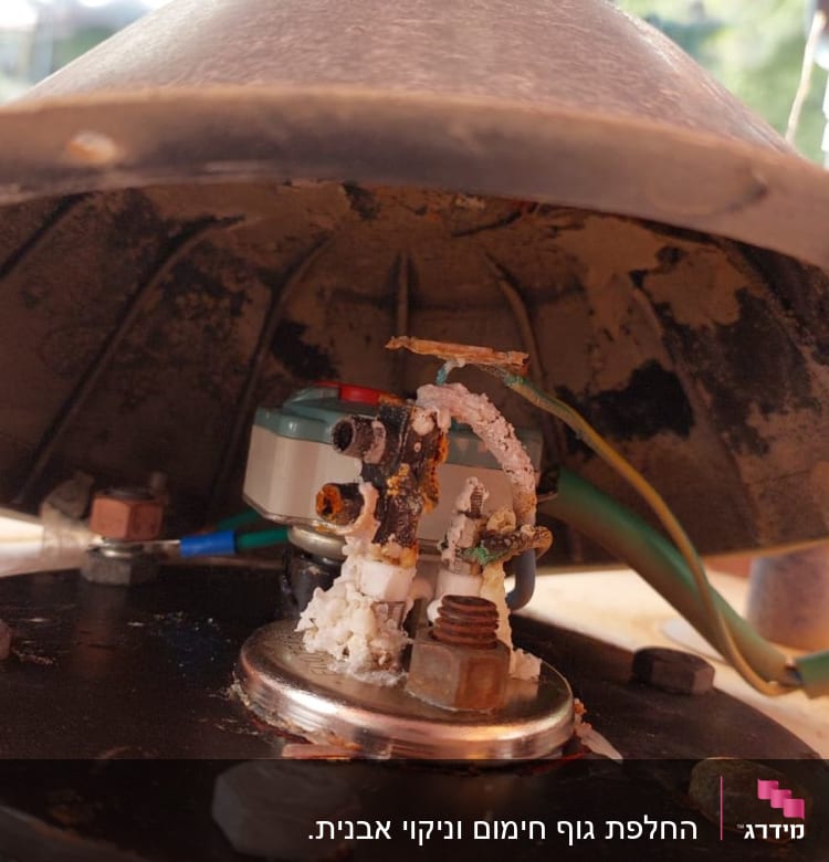 חלקים פנימיים של דוד שמש עם חלודה וחיבורים חשמליים
